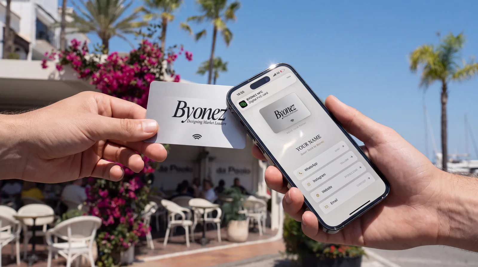 A Byonez Smart Touch card tapped against an iPhone by the Puerto Banús marina — the phone opens the Byonez page instantly.